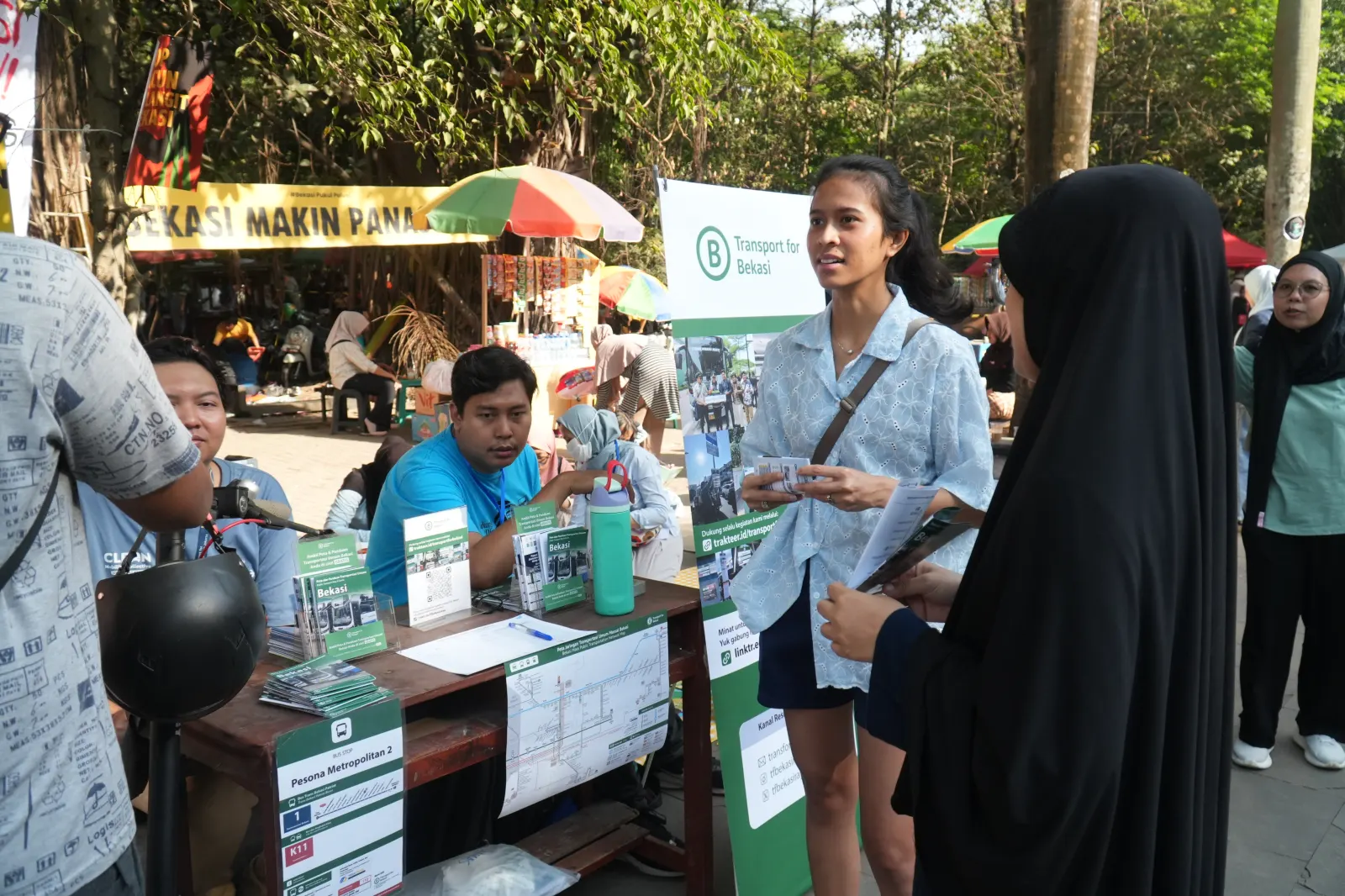 Beberapa orang sedang berbincang di booth Transport for Bekasi yang menyediakan peta transportasi umum Bekasi secara gratis.