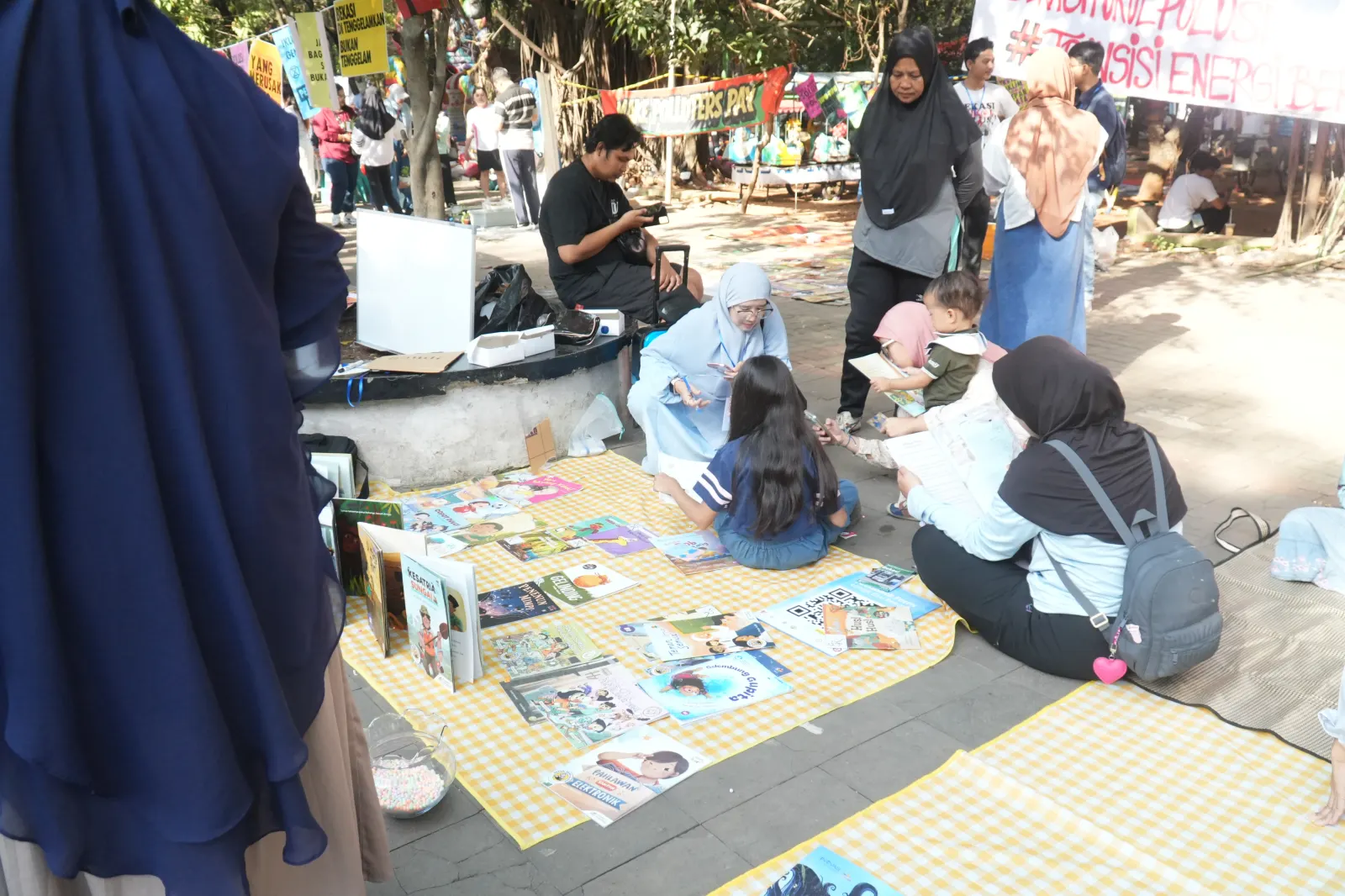 Beberapa anak bersama ibunya sedang membaca bersama di booth Bekasi Read Aloud.