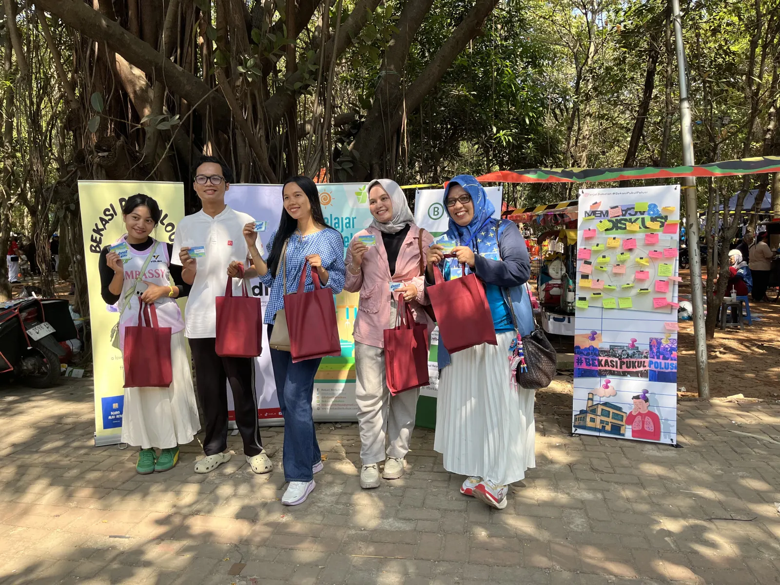 Lima orang pemenang reels challenge sedang berpose dengan menunjukkan hadiah, yaitu e-money dengan logo Langit Biru Project dan lampu rechargeable.